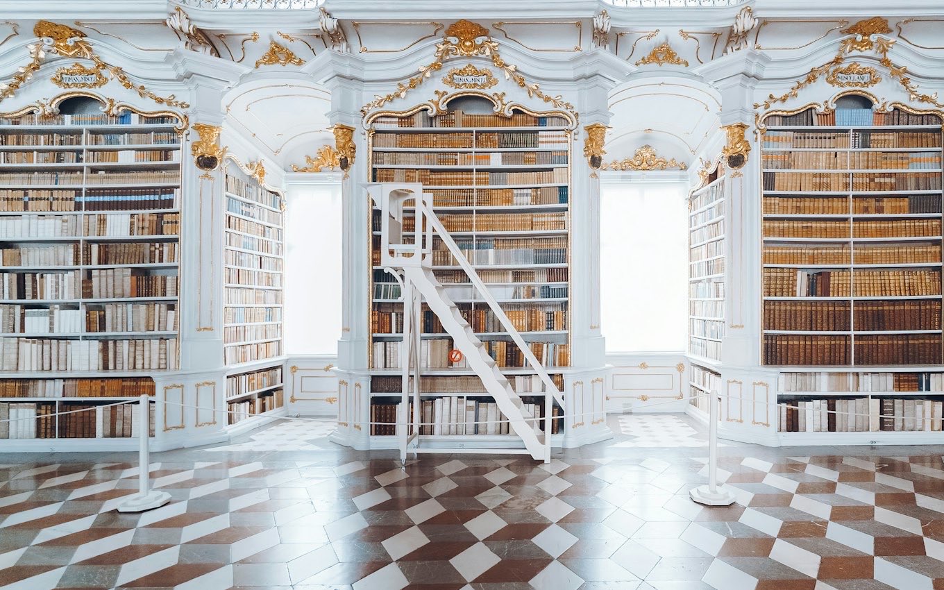 Tall white library shelves full of books
