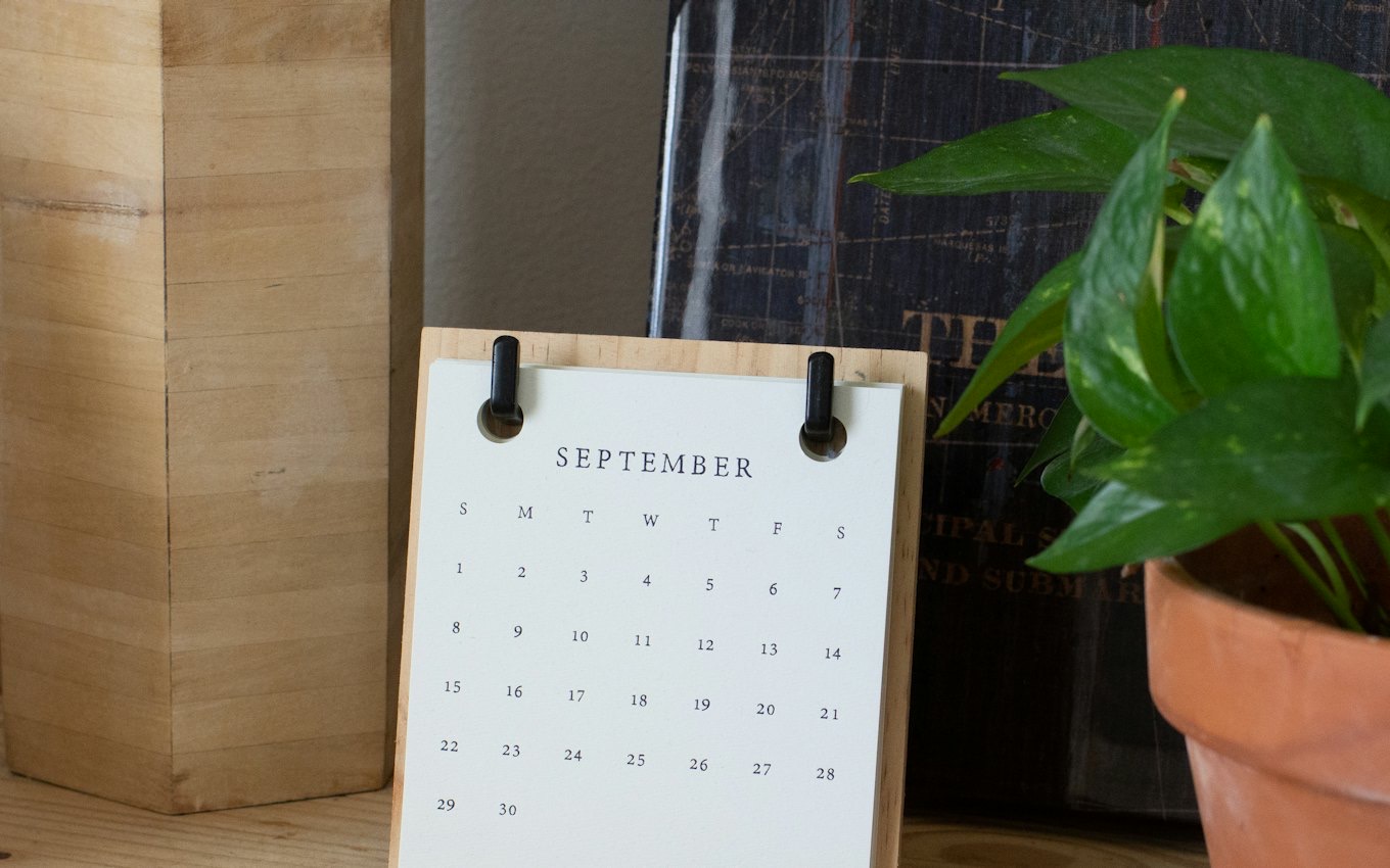 A paper desk calendar on a wooden table