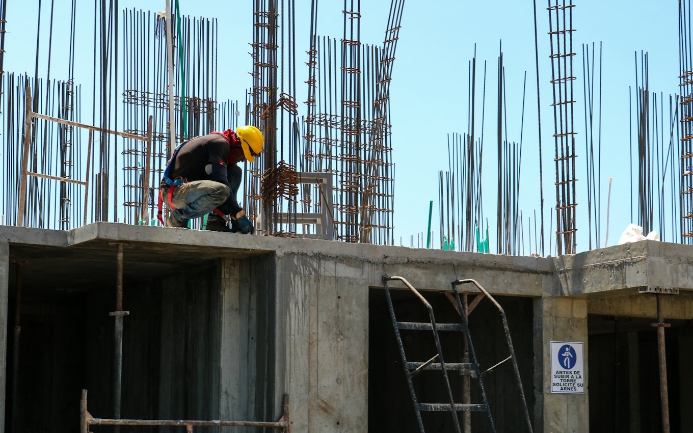 A construction worker on the frame of an unfinished building