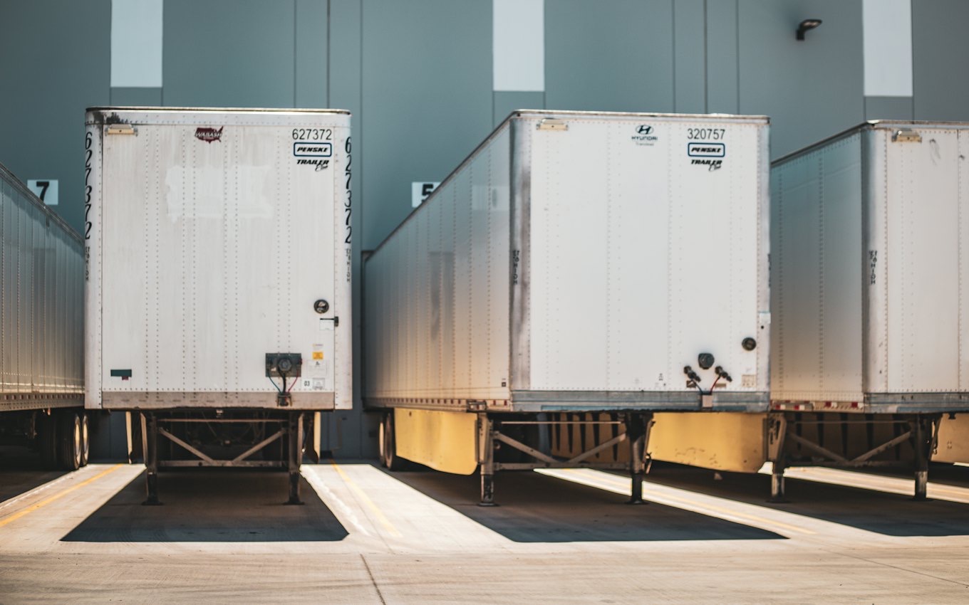 White box trucks parked at warehouse loading docks