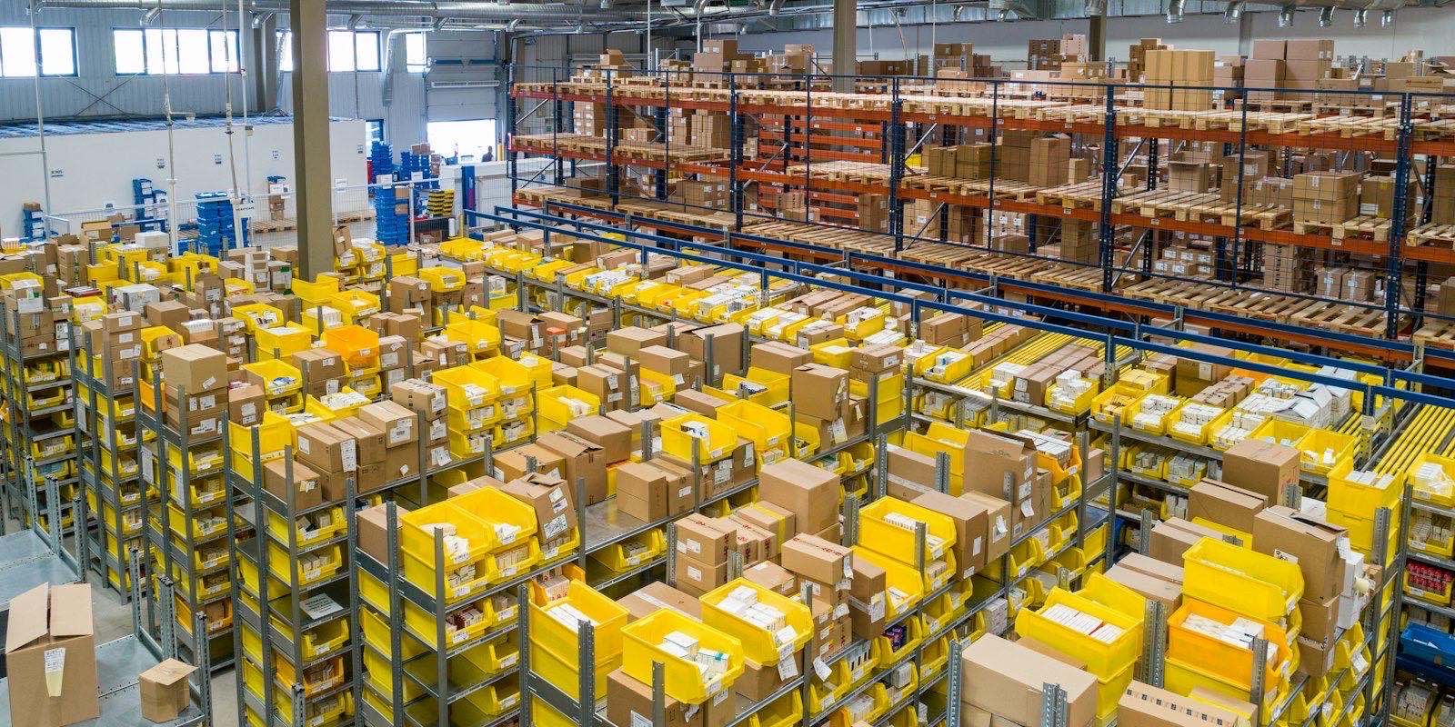 Rows of yellow and white storage crates on warehouse racks